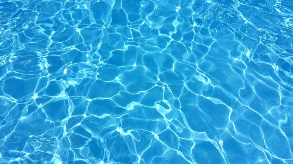 Crystal clear blue pool water on a sunny day.