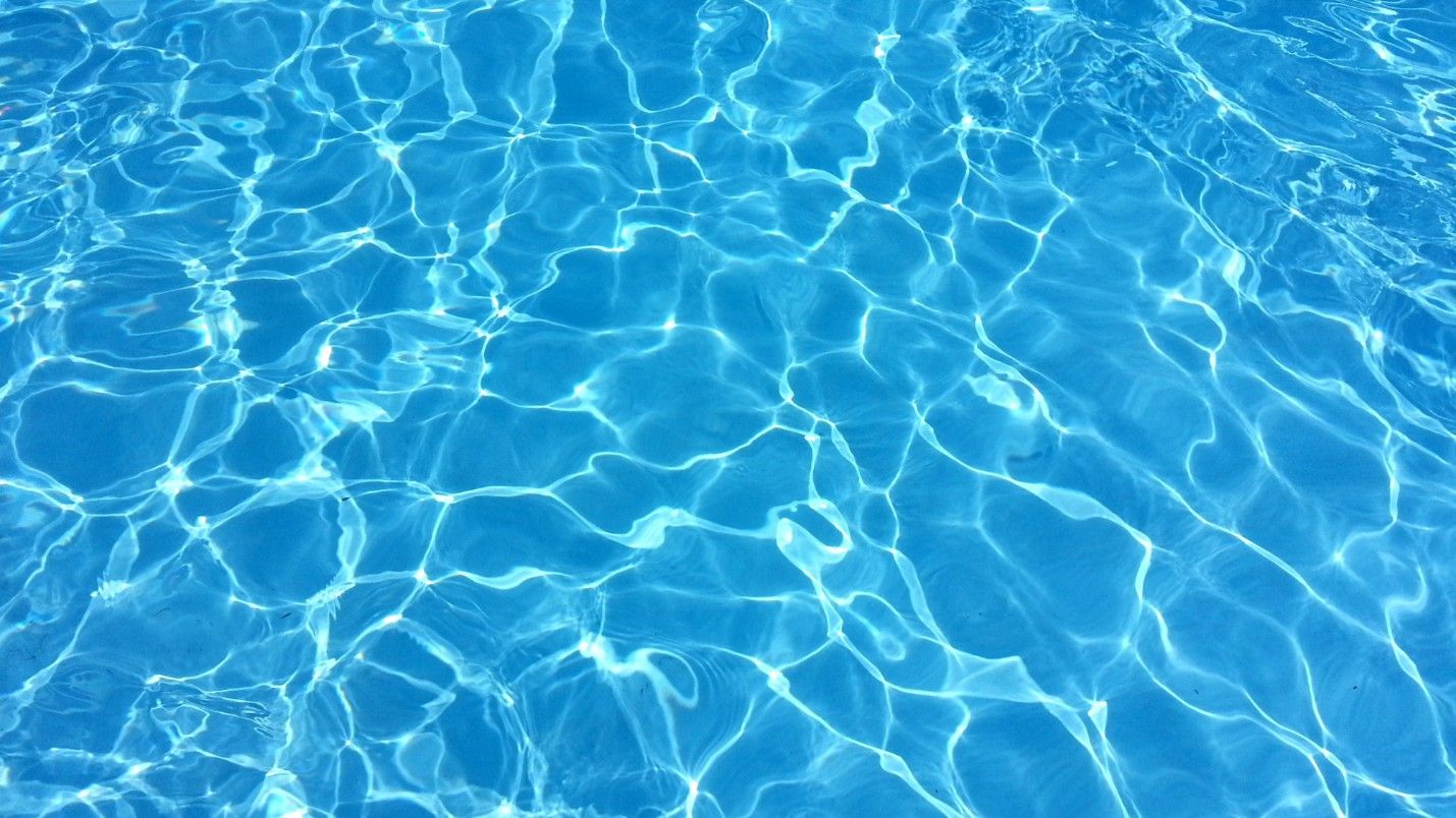 Crystal clear blue pool water on a sunny day.